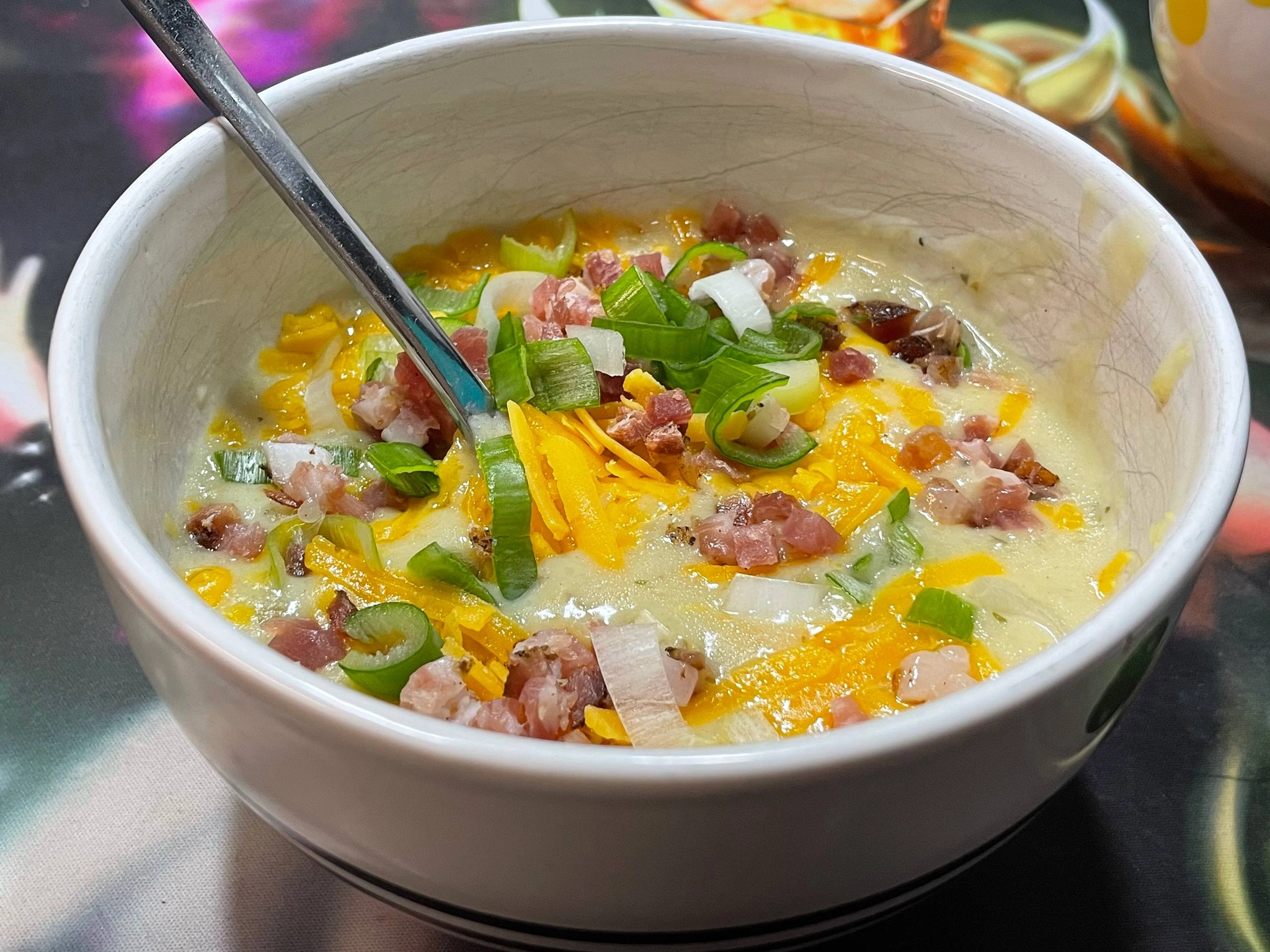 the creamy white soup base in a bowl topped with cheddar and bacon