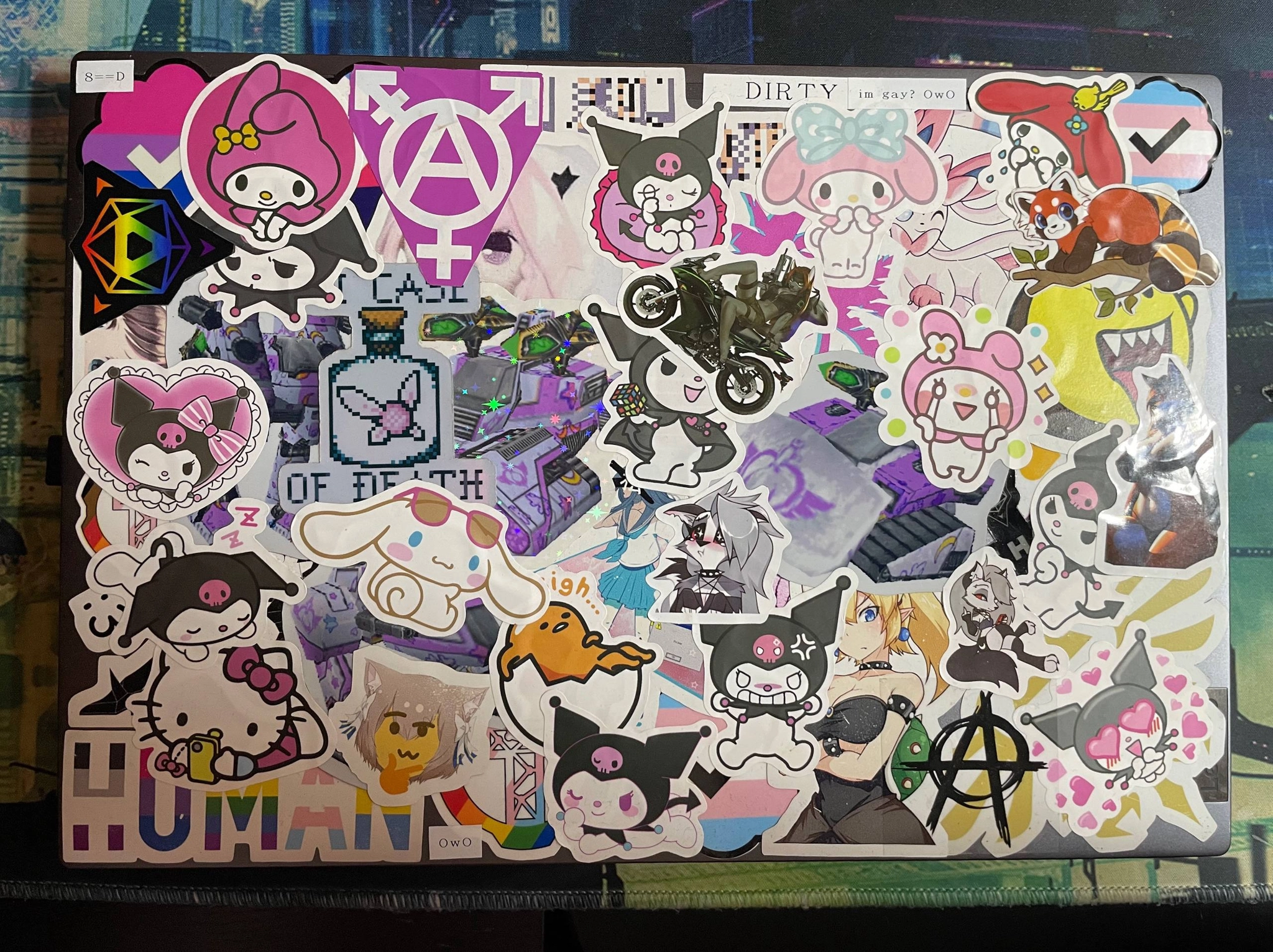 a thinkpad covered in stickers of various characters overlayd on top of eachother
